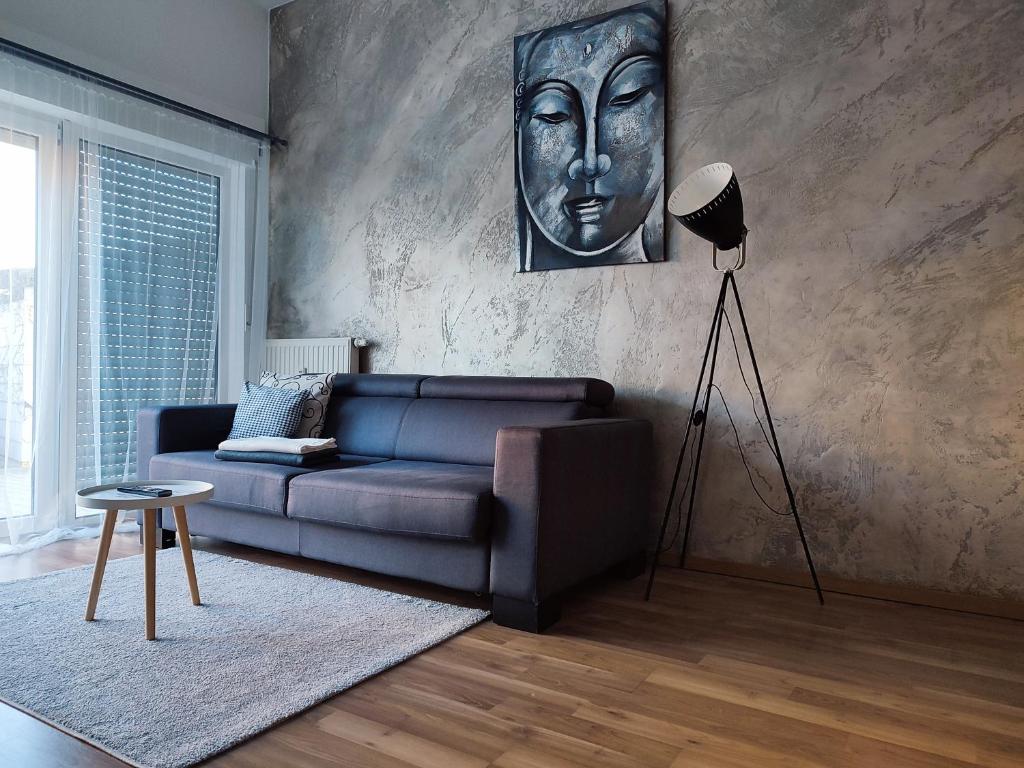 a living room with a blue couch and a statue at Ferienwohnung Susanna in Friedrichshafen