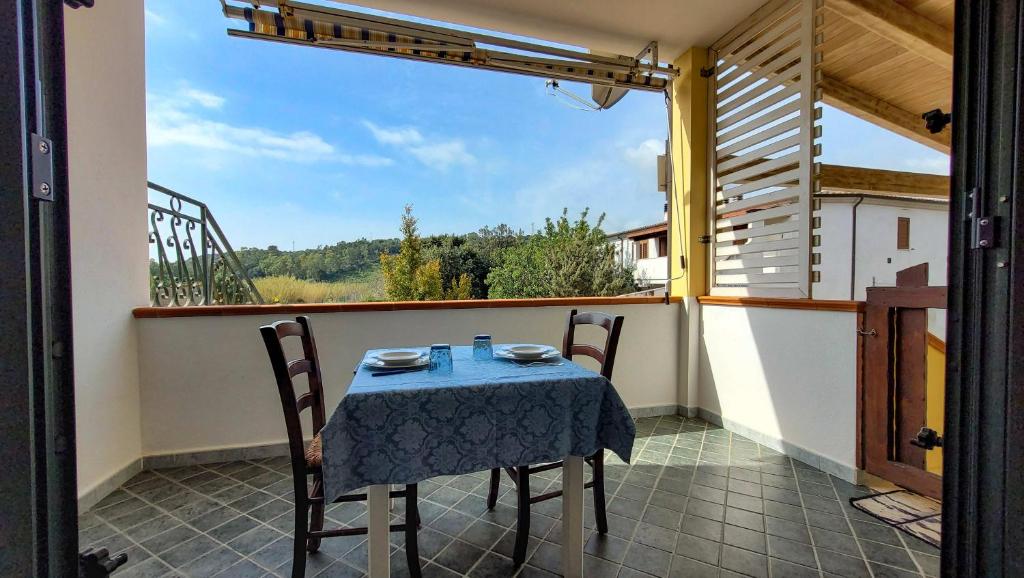 un tavolo e sedie su un balcone con vista di Rossy house Orosei a Cala Liberotto
