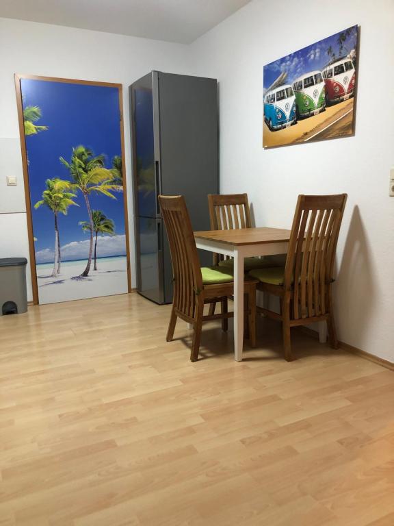 a dining room with a table and chairs and a painting at Ferienwohnung TOBI in Bad Dürrheim