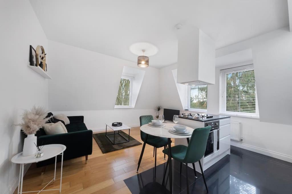 een keuken en een woonkamer met een tafel en stoelen bij Roomy One bed loft apartment in Bishops Stortford