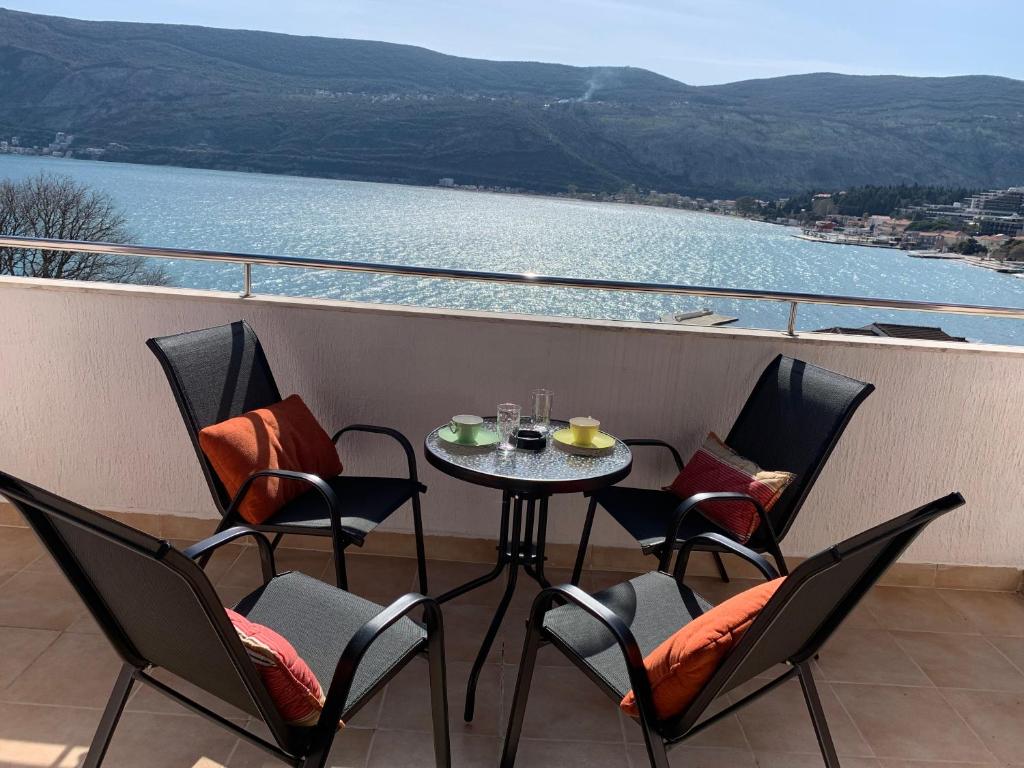 イガロにあるDanielのテーブルと椅子、水辺の景色を望むバルコニー