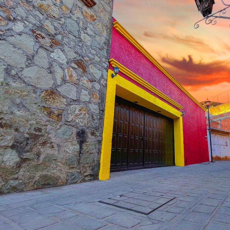 a red and yellow building with a garage at Bokatrip Xochimilco in Oaxaca City