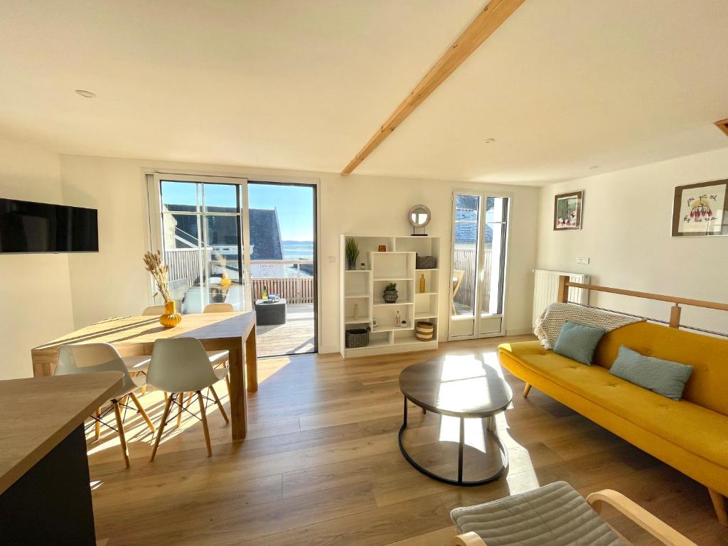 un salon avec un canapé jaune et une table dans l'établissement Ker Lina, à Locmariaquer