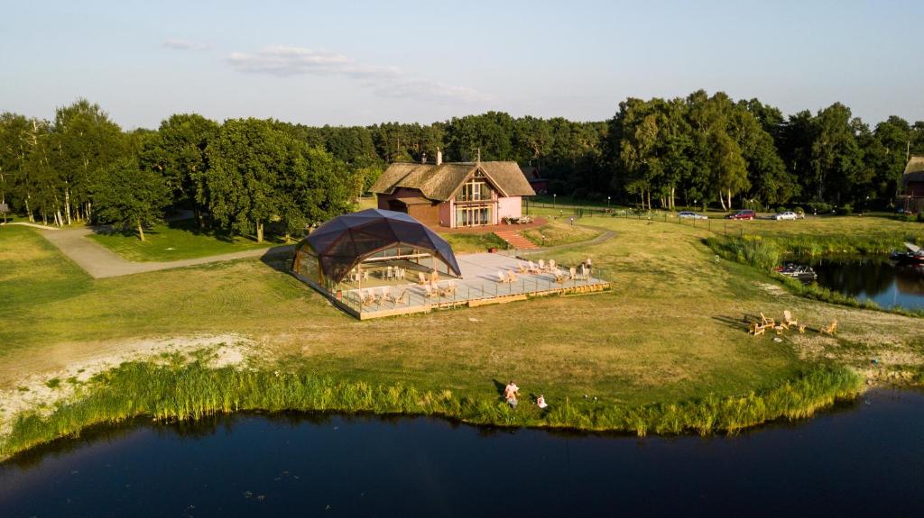 an aerial view of a house on a hill next to a lake at Svencelė Resort in Svenele