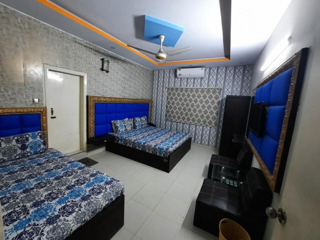 a hotel room with two beds and a tv at Capital Lodge Gulistan-e-Johar in Karachi