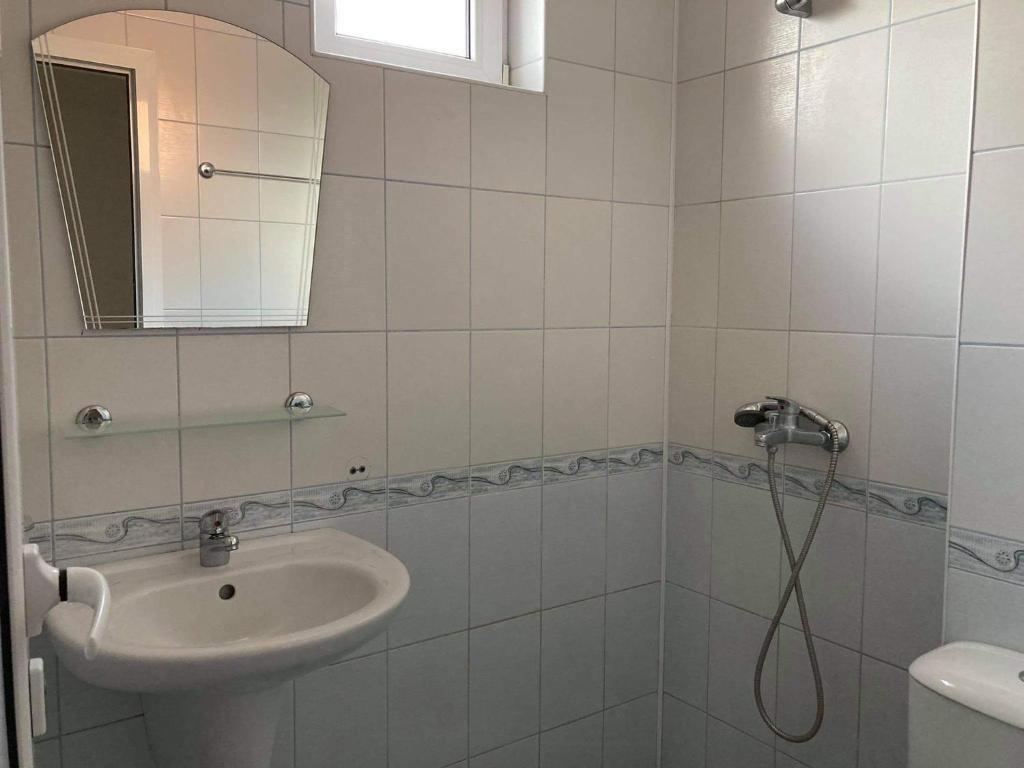 ネセバルにあるАпартаменти за семеен комфортен отдих в Равдаの白いバスルーム(シンク、シャワー付)