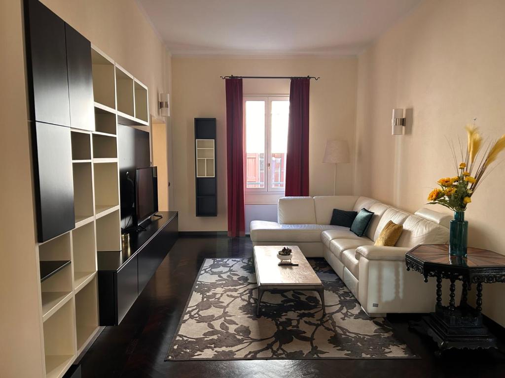 a living room with a white couch and a tv at Piazza Maggiore Luxury Apartment in Bologna