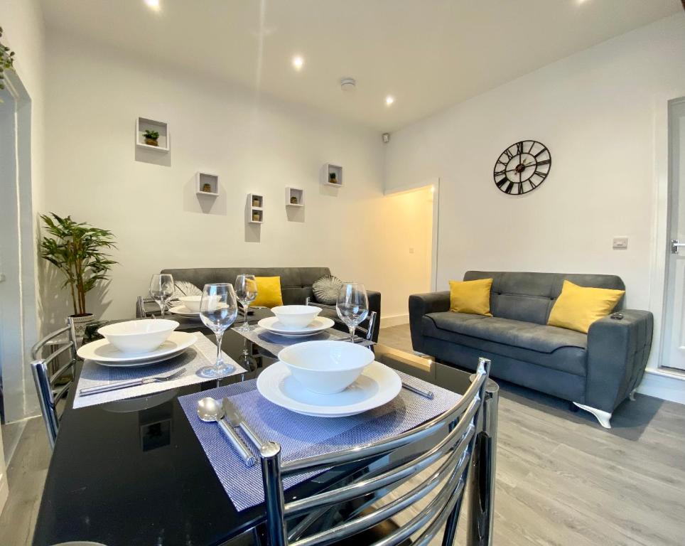 a dining room with a table and a couch at Emerald Properties UK - Stoke-on-Trent City Centre, close to Alton Towers in Stoke on Trent