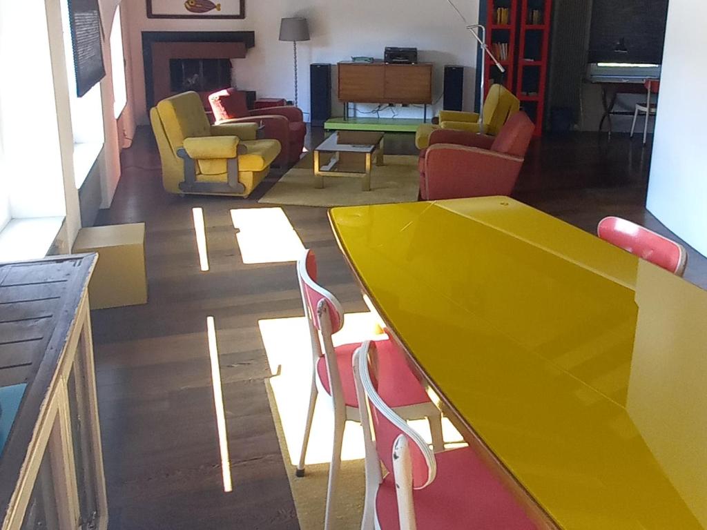 una mesa amarilla y sillas en la sala de estar. en La casa di Arnaldo "Punarinta", en Agno