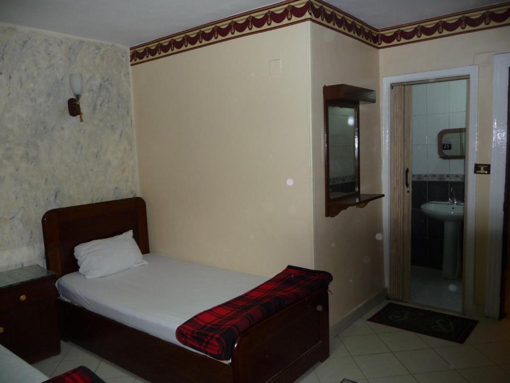 a small bedroom with a bed and a bathroom at Venus Hostel in Cairo