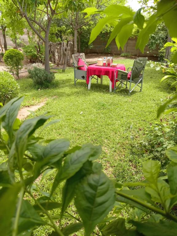 einen roten Tisch und Stühle im Hof in der Unterkunft Ledoba Bed & Breakfast 