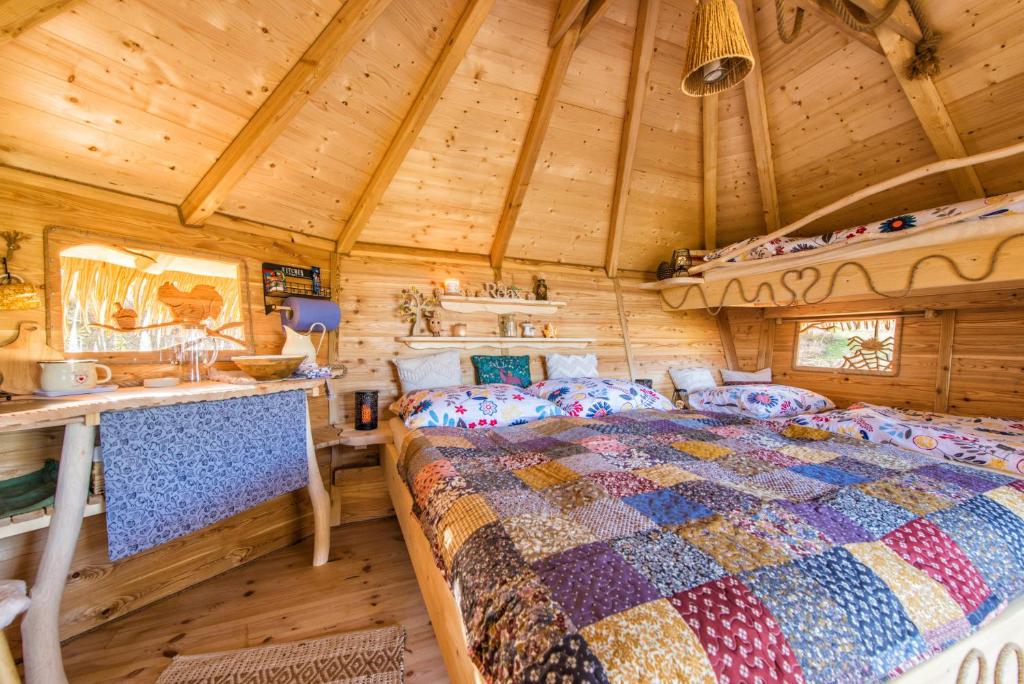 een slaapkamer met een bed in een houten hut bij ARBORdomcek in Horná Lehota