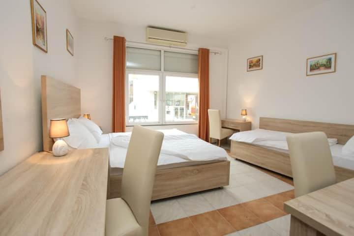 a bedroom with two beds and a table with a lamp at Lovely Home Rooms & Apartments in Mostar