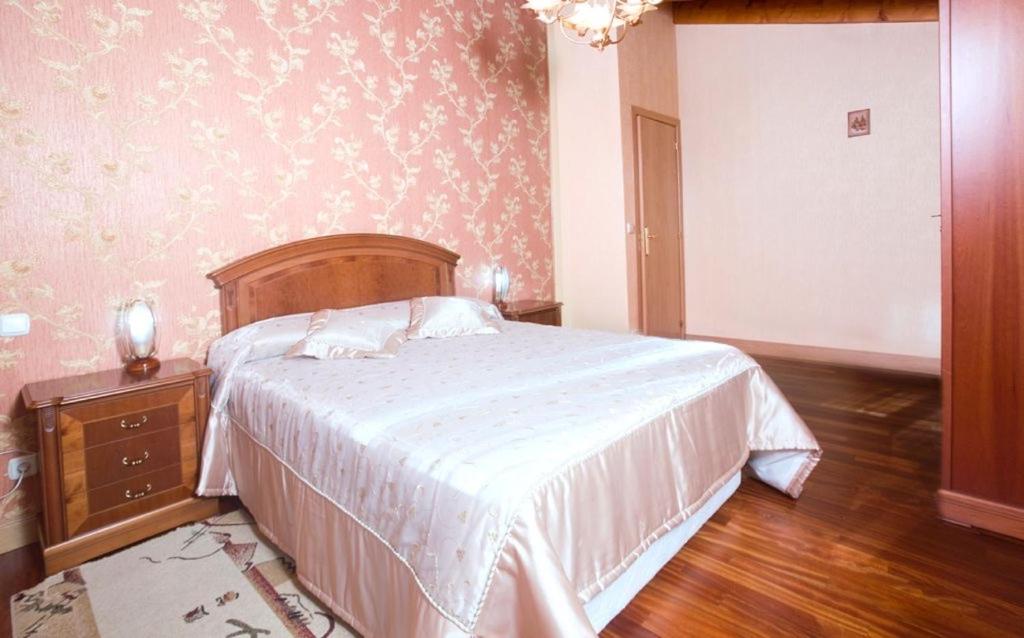 萊薩卡的住宿－Chalet en Lesaka, cerca de San Sebastián，一间卧室配有一张带白色床罩和桌子的床。