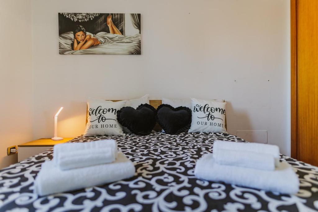 una camera con un letto bianco e nero con due cuscini di Next Door elegante villa a Bari a Valenzano