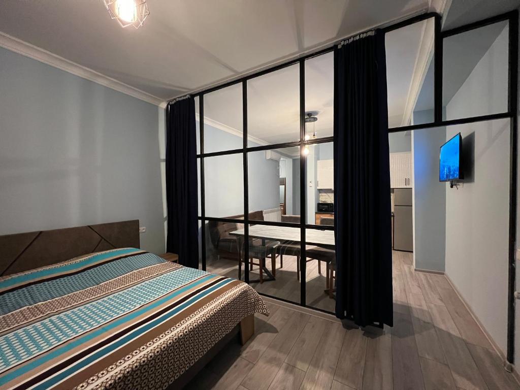 um quarto com uma cama e uma sala de jantar em Apartment Merabi em Batumi