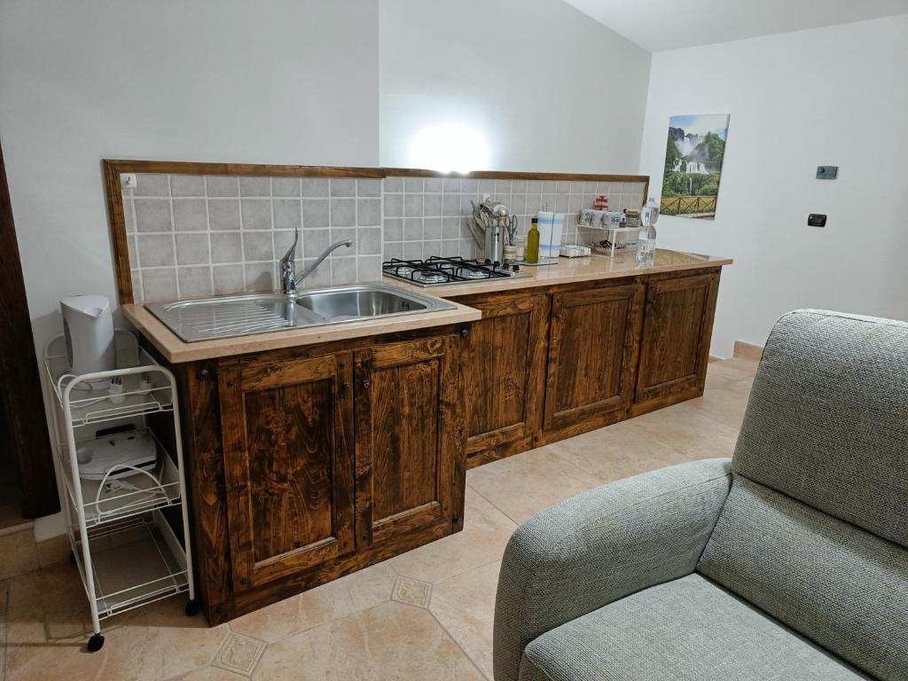 een keuken met een wastafel, een fornuis en een bank bij La mansardina di nonno Biagio in Bastia Umbra