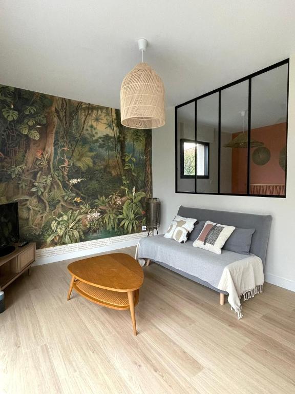 - une chambre avec un lit et une grande peinture murale dans l'établissement Au Petit Manoir, à Montbert