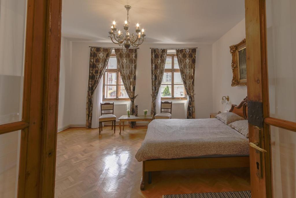 Schlafzimmer mit einem Bett und einem Kronleuchter in der Unterkunft Illo Tempore - Ultracentral Apartment in Sighişoara