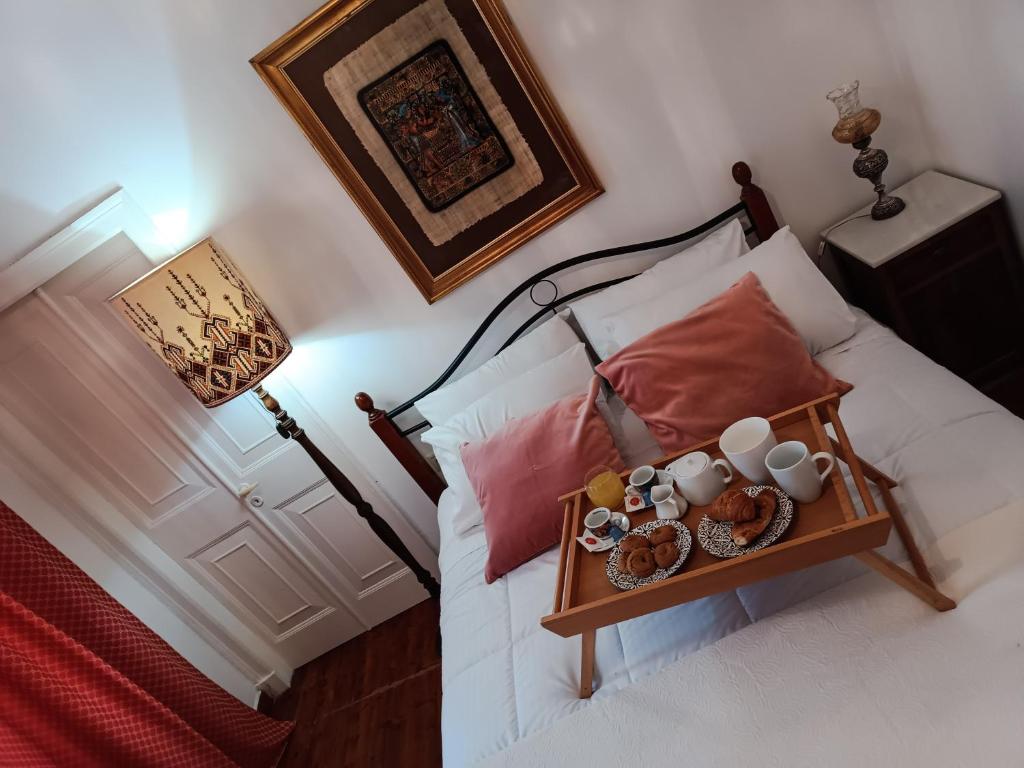 Una cama con una bandeja de comida. en Vintage & Art apartment, en Corfú