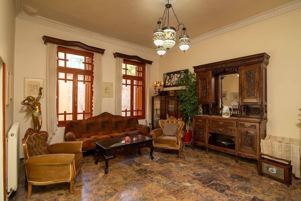 a living room with a couch and chairs and a mirror at Mikos Mansion in the city center in Mytilini