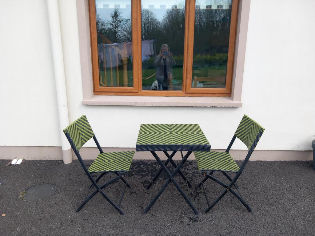 twee stoelen en een tafel voor een raam bij Larchlodge in Ennis