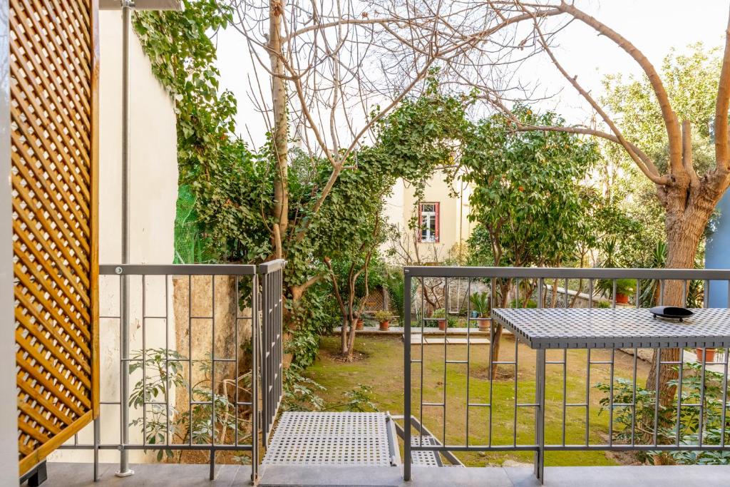einen Balkon mit einem Tisch und einem Zaun in der Unterkunft Secret Garden Downtown in Athen