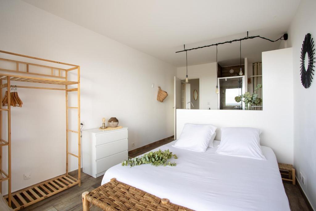una camera con 2 letti bianchi e uno specchio di Vue mer, terrasse et parking privé a Antibes