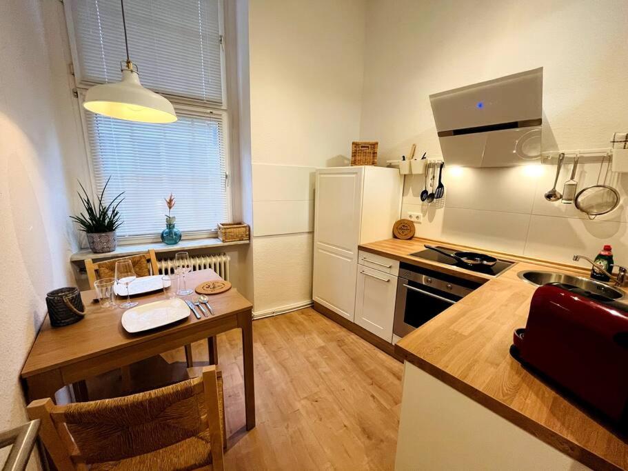 una pequeña cocina con mesa y nevera en Central-City-Apartment - Innenstadt Wuppertal en Wuppertal
