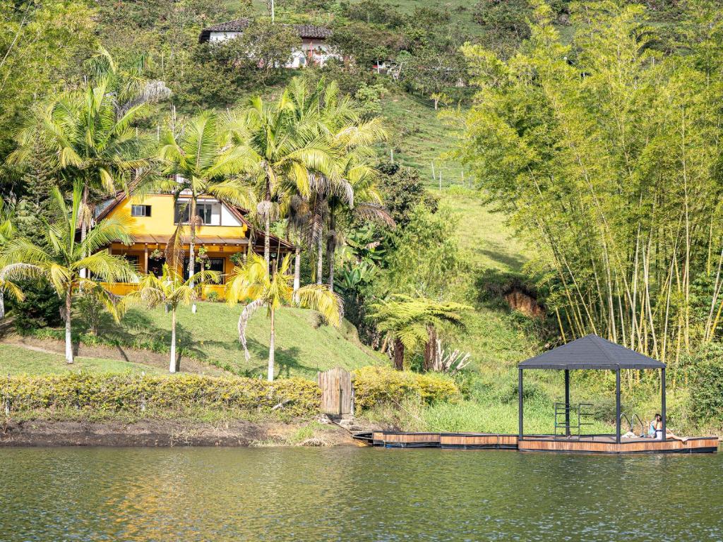 een huis op een heuvel naast een waterlichaam bij VOLARE Experience in Guatapé