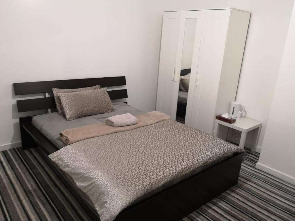 a bedroom with two beds and a mirror at White House "Luton Airport" in Luton