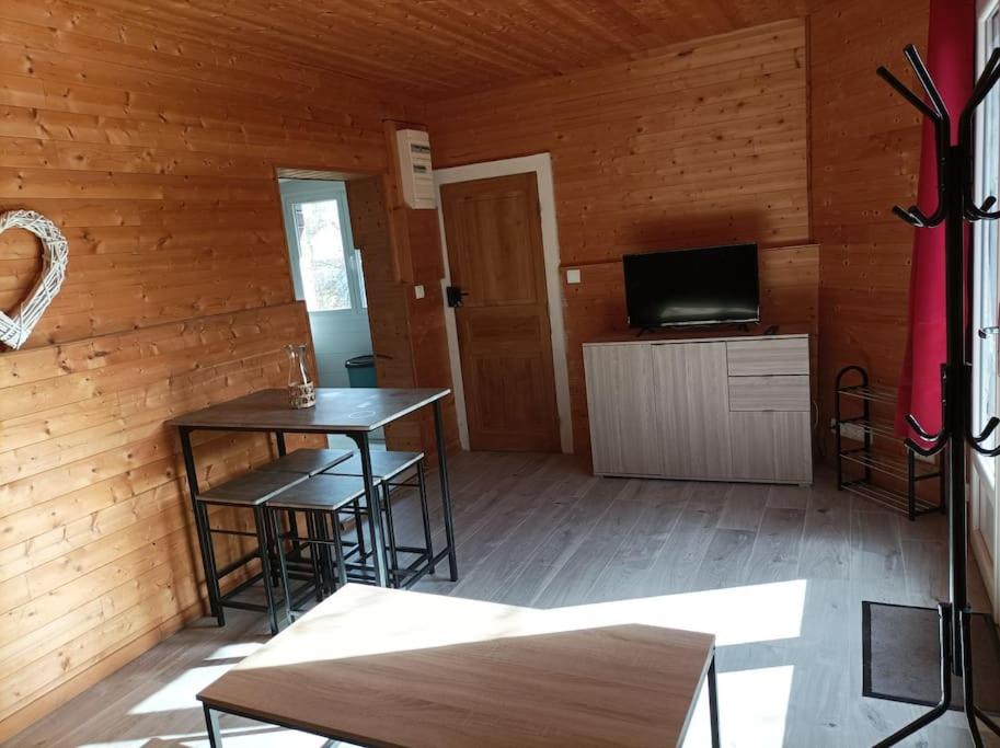 a room with a table and chairs in a cabin at Chez Julien et Mélanie in La Frugerie