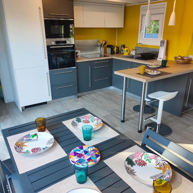 a kitchen with a table with plates on it at Le Colorful in Dinard