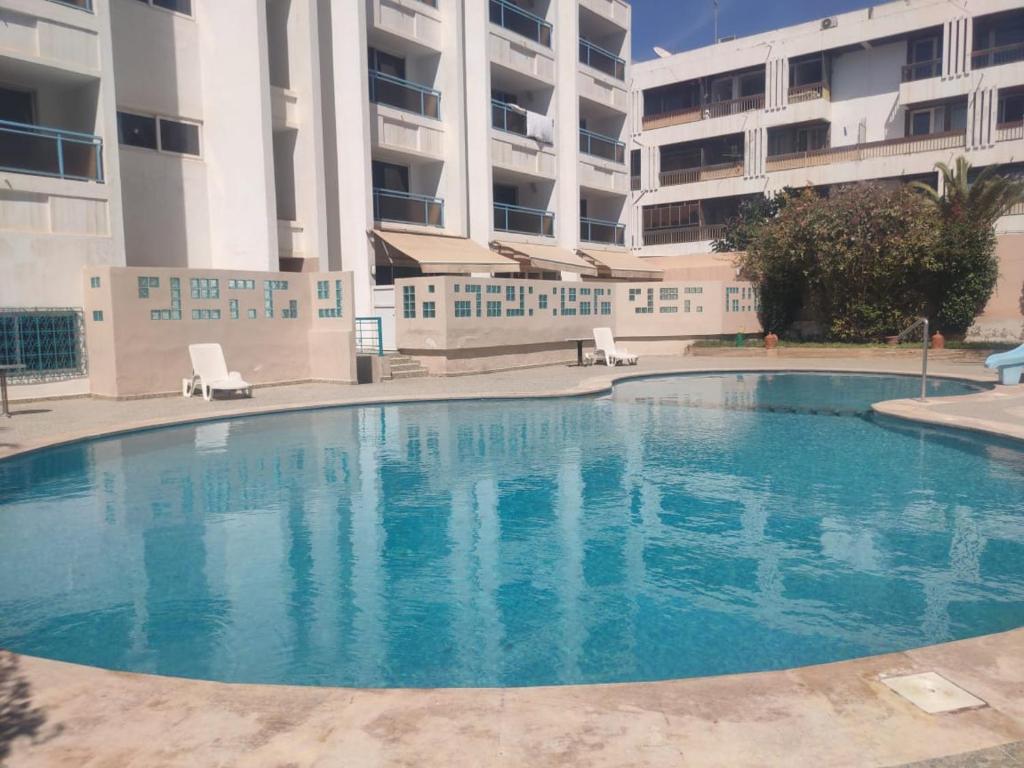 an empty swimming pool in front of a building at Hôtel Résidence Louban in Agadir