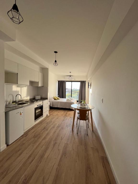 eine Küche und ein Wohnzimmer mit einem Tisch in einem Zimmer in der Unterkunft Monoambiente Urquiza in Buenos Aires