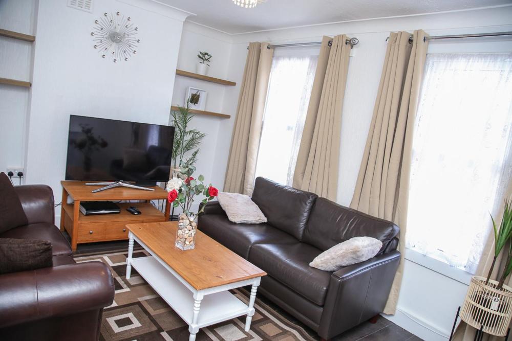ein Wohnzimmer mit einem Ledersofa und einem Couchtisch in der Unterkunft Newly Refurbished 3 Bedroom House close to Central London in London