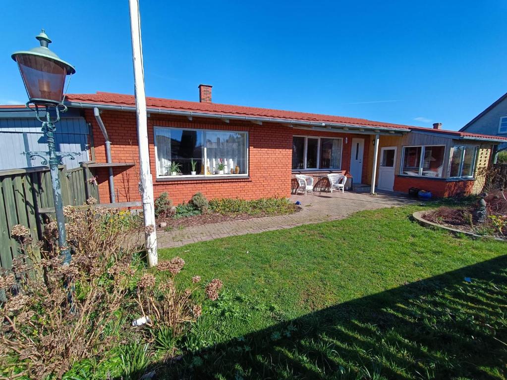 a red brick house with a yard with a yard at Svendborg, Thurø ferievilla in Svendborg