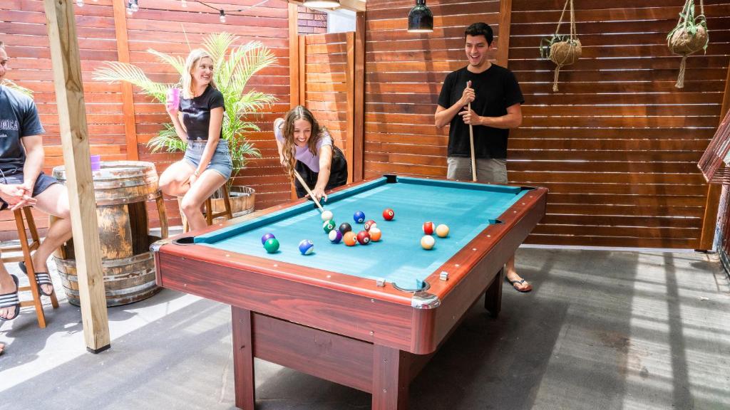 a group of people standing around a pool table at Mad Monkey Downtown in Sydney