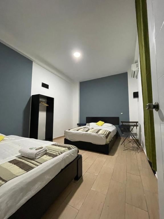 ein Schlafzimmer mit 2 Betten und einem Tisch darin in der Unterkunft Hotel Central in Tarapoto