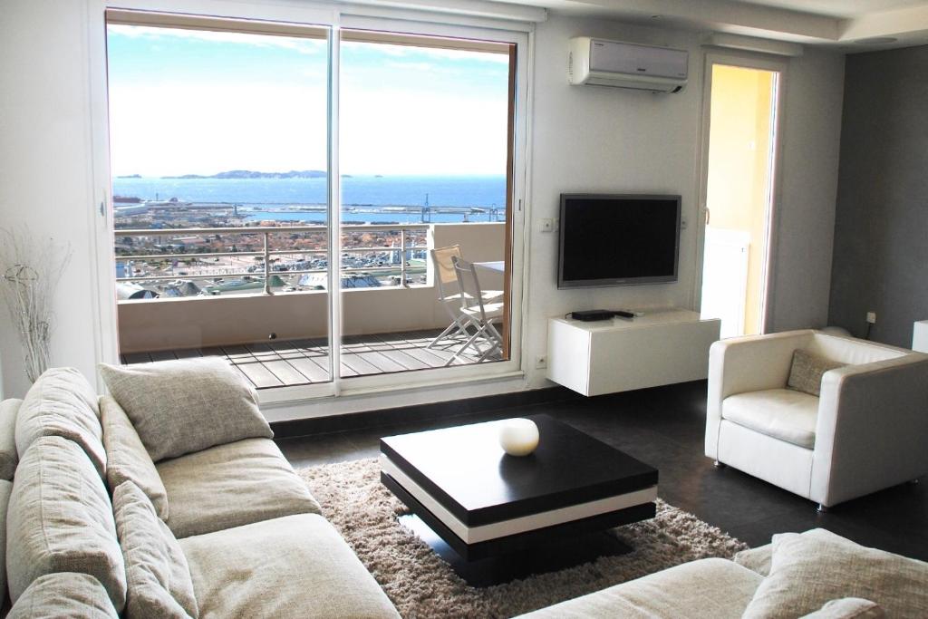 een woonkamer met een bank en een groot raam bij Loft Vue Mer in Marseille