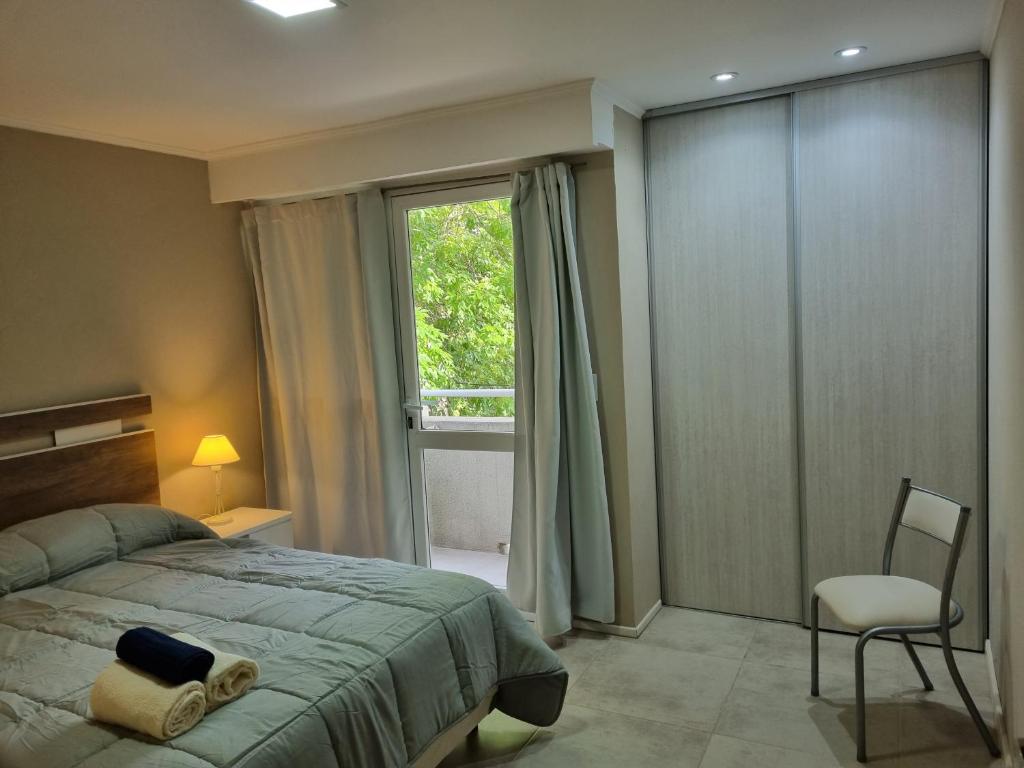 a bedroom with a bed and a window and a chair at Departamento centro in General Juan Madariaga