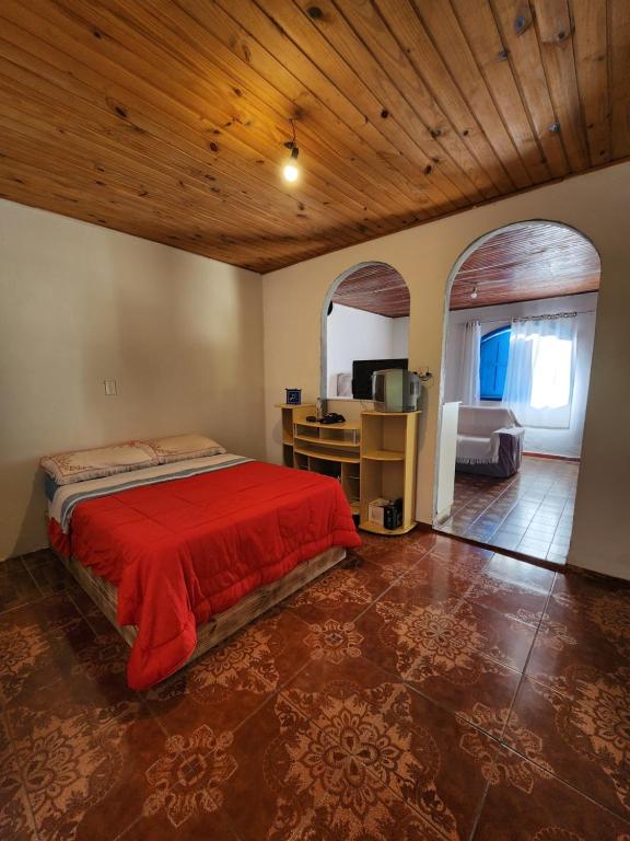 a bedroom with a bed and a desk in a room at Hospedaria e Camping Quintal do Mundo in Lumiar