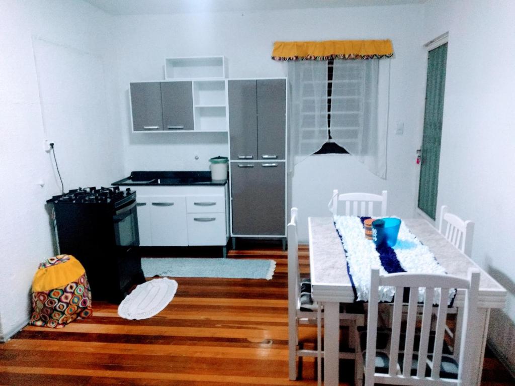 een keuken met een tafel met stoelen en een koelkast bij Casa apto Bento Gonçalves Serra Gaúcha in Bento Gonçalves