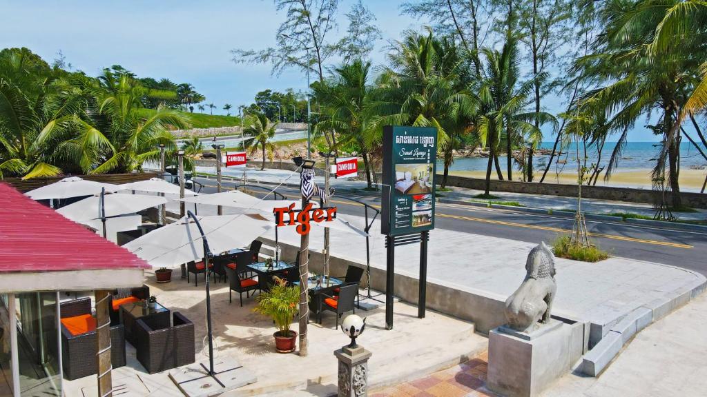 una strada con un cartello stradale e una spiaggia di Sunset Lounge a Sihanoukville