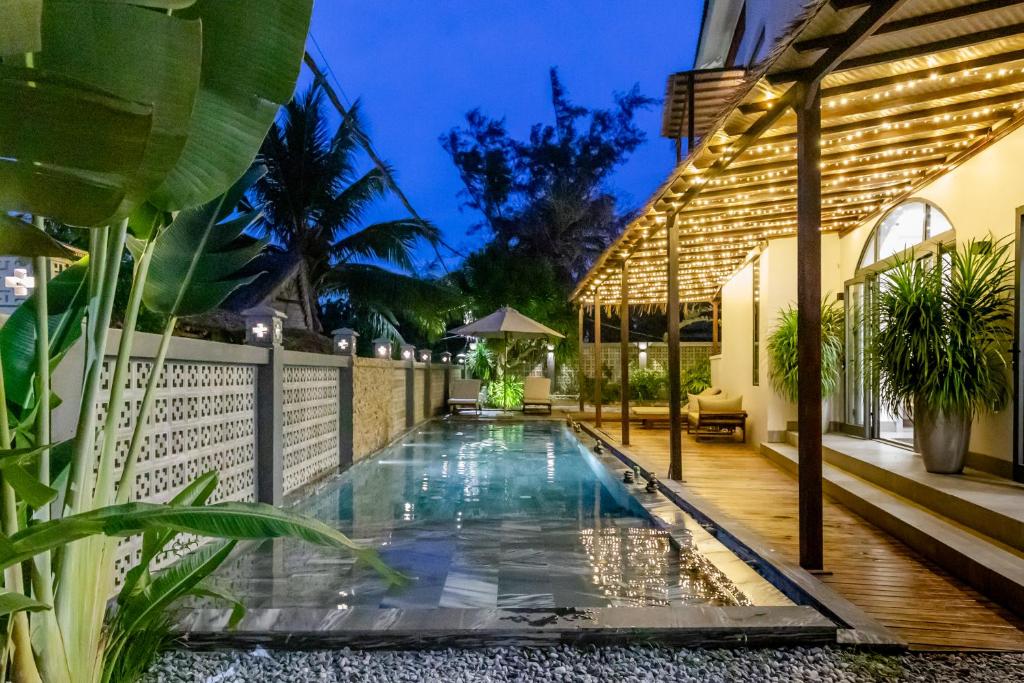 uma piscina no quintal de uma casa em The Watermark Beachside Hotel em Hoi An