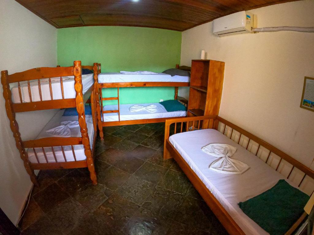 a room with three bunk beds in a house at Pousada Relíquias do Mar in Arraial do Cabo