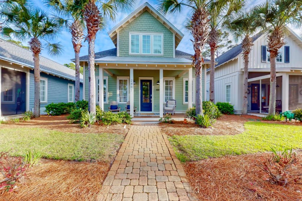 une maison avec des palmiers devant elle dans l'établissement Barefoot Bungalo, à Destin