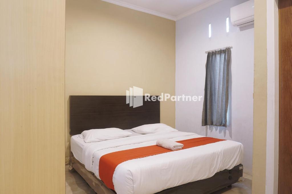 um quarto com uma cama grande num quarto em Tassa Homestay Syariah Mitra RedDoorz em Jambi