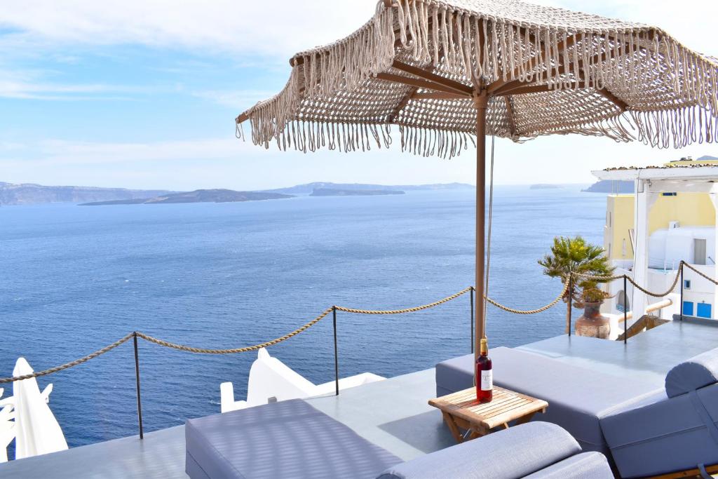 - Patio con sombrilla y vistas al océano en Oinos Luxury Suites Caldera, en Oia