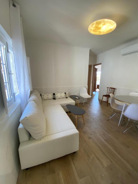a living room with a white couch and a table at Casa Terraza de los Aljibes in Toledo